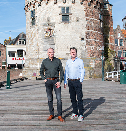 Twee makelaars staan op de brug voor de toren.